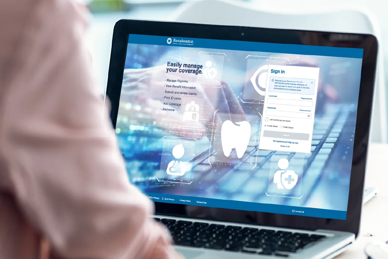 A woman in a pink blazer with her back to the camera is looking at an employer portal on a laptop.