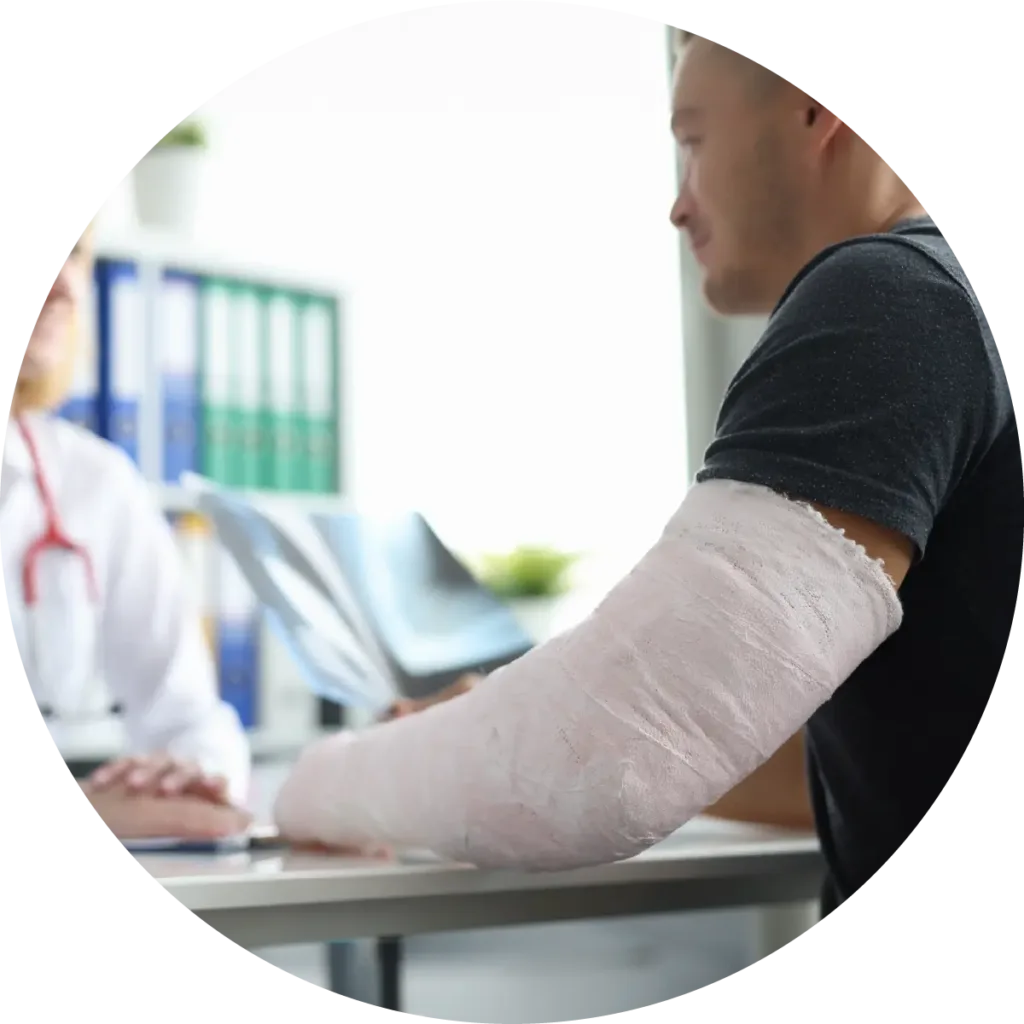 At the doctor's office, a man with a broken arm holds his X-ray as the doctor explains the images.