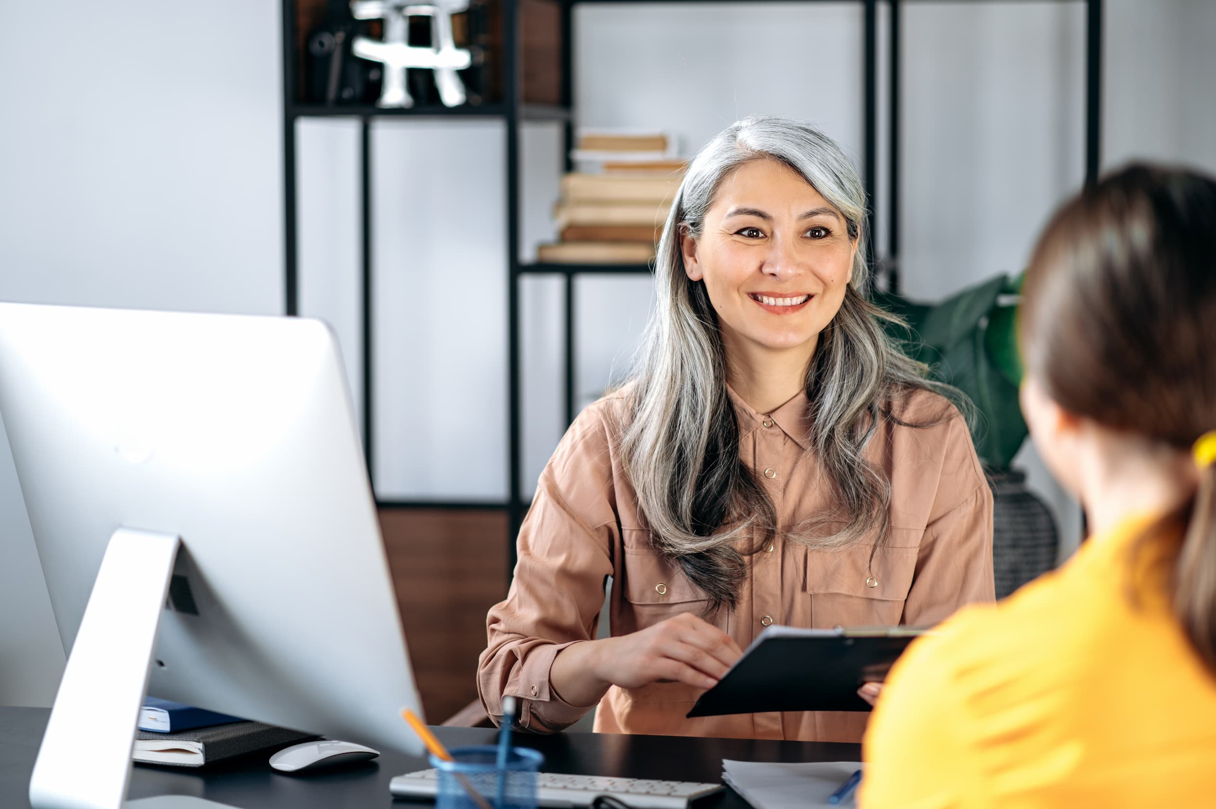 HR representative meets one-on-one with an employee in an office.