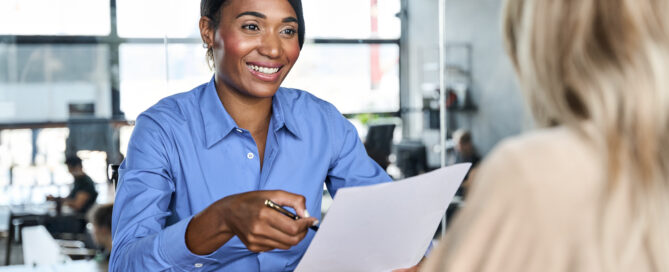 Broker reviewing benefits paperwork with an employer during a meeting about bundled ancillary coverage.