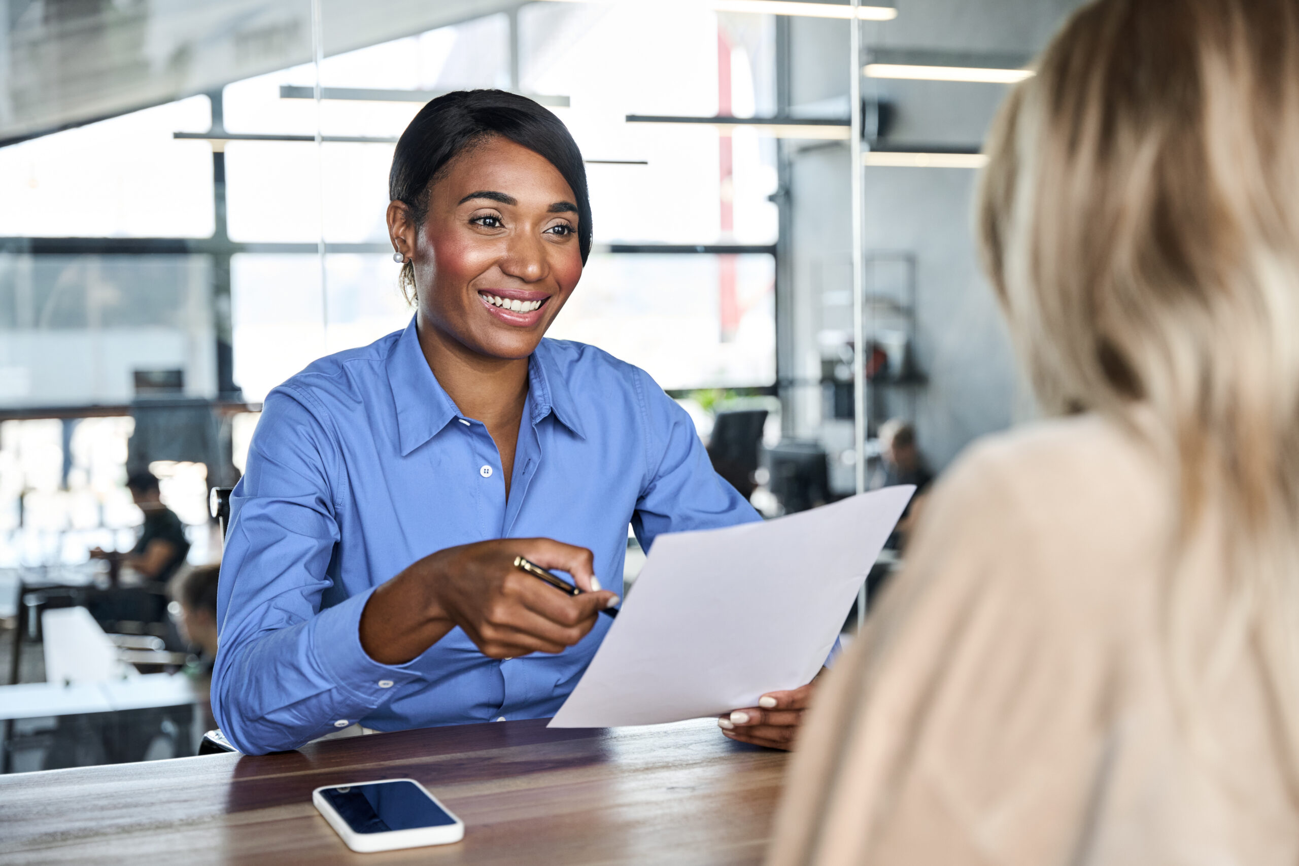 Broker reviewing benefits paperwork with an employer during a meeting about bundled ancillary coverage.